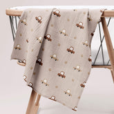 Cars print muslin swaddle draped on wooden table